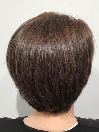 Nachher-Foto: Rückansicht einer Frau mit kurzen brünetten Haaren ohne graue Haare nach der Färbung.