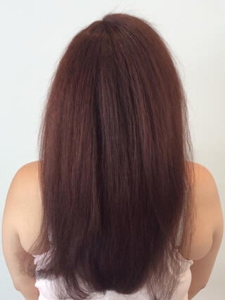 Nachher-Foto: Rückansicht einer Frau mit langen, gesunden roten Haaren nach dem Färben.