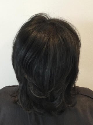 Nachher-Foto: Rückansicht einer Frau mit kurzen schwarzen Haaren ohne graues Haar nach der Färbung.