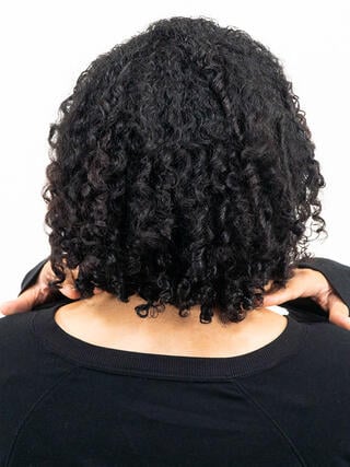 Nachher-Foto: Rückansicht einer Frau mit kurzen schwarzen Haaren und ebenmäßiger Haarfarbe.